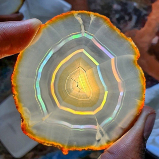 Iris Agate slice from Brazil. Due to very fine banding within the stone, light passing through is refracted, resulting in bands of rainbows.